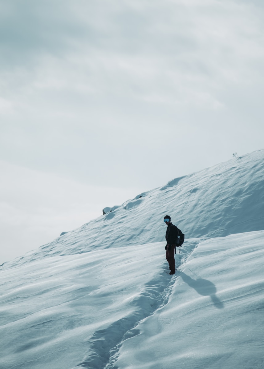 a person walking up a snow covered hill