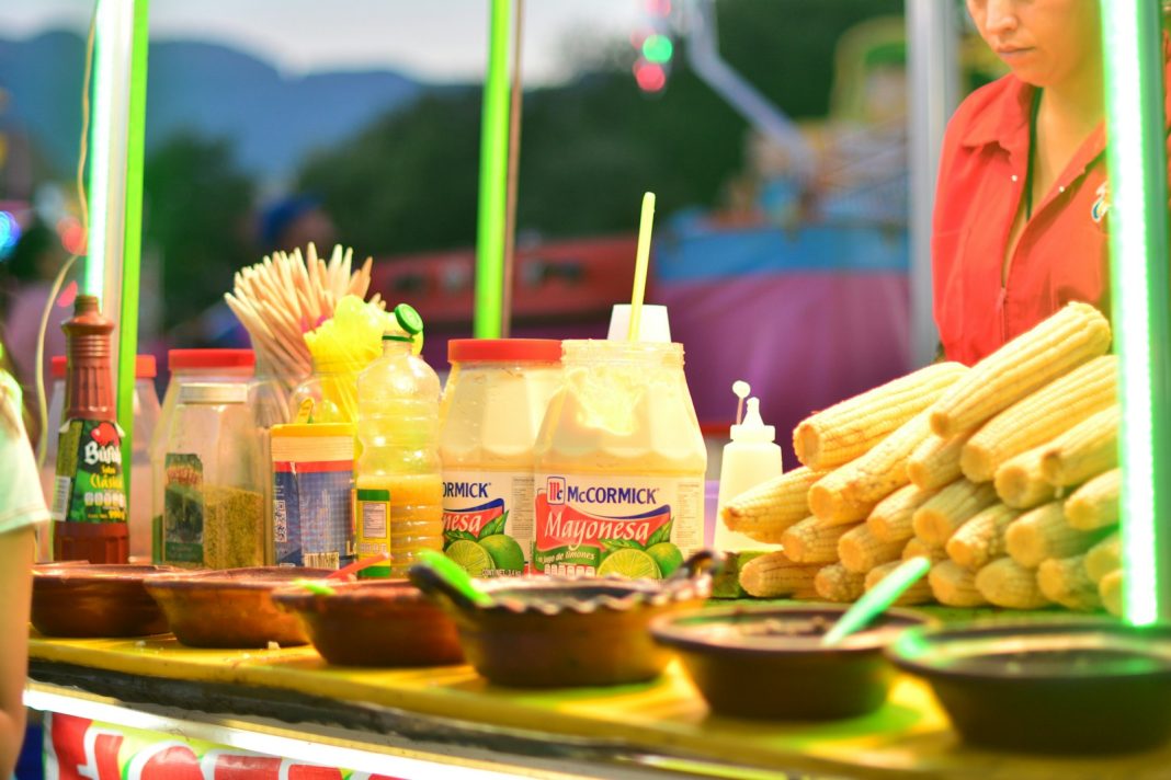 shallow focus photo of bottles near yellow corns