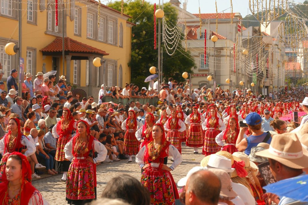 People in traditional costumes marching in a street parade.