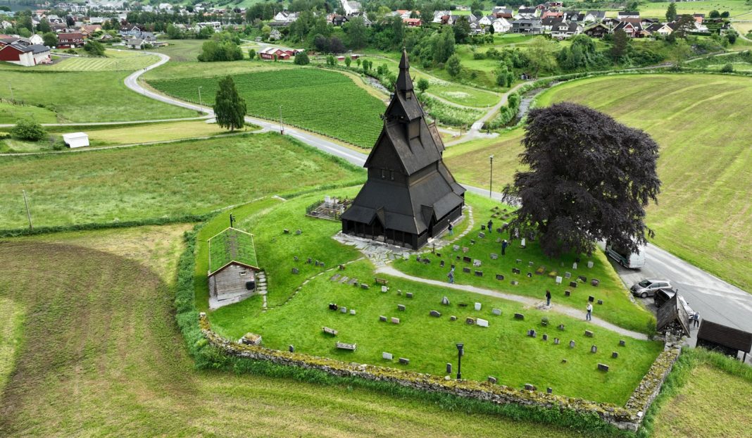 a large green landscape with a building and a tree