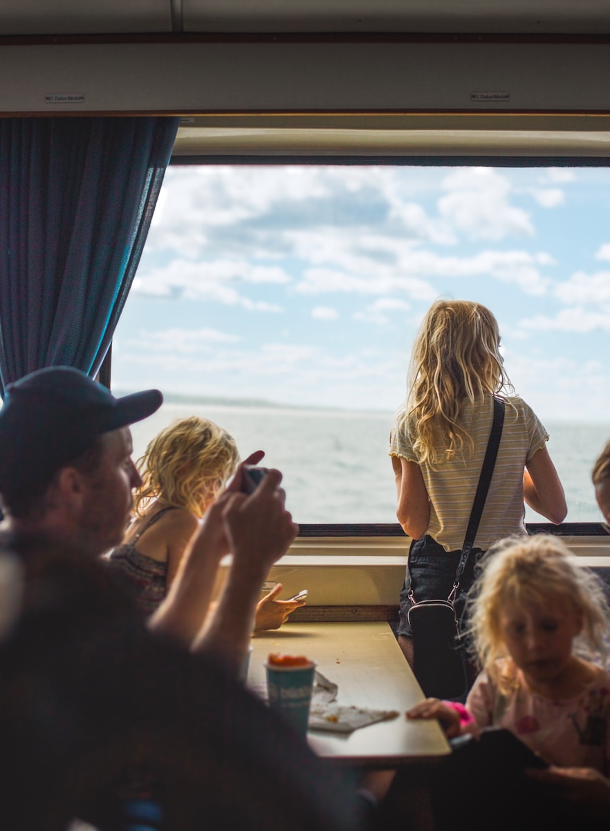 A group of people sitting at a table in front of a window