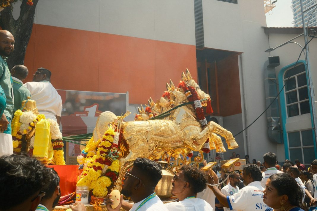 A group of people standing around a golden horse
