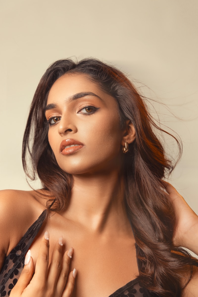 A woman with dark hair and makeup looks forward.